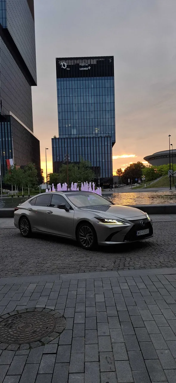 Lexus ES300h — sylwetka boczna na tle podświetlanej fontanny